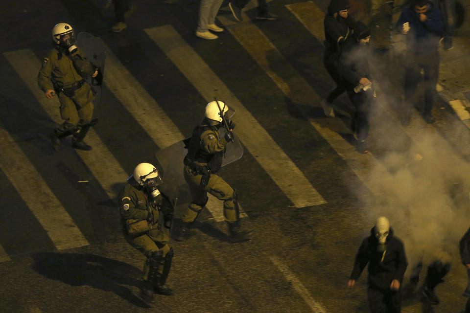 Greek riot police throw tear gas grenades during clashes with demonstrators opponents of Prespa Agreement outside the Greek Parliament in Athens, Thursday, Jan. 24, 2019. Greek lawmakers are debating a historic agreement aimed at normalizing relations with Macedonia in a stormy parliamentary session scheduled to culminate in Friday vote. (AP Photo/Petros Giannakouris)