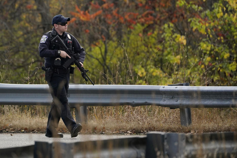 A police officer walks along a rural road during a manhunt for the Maine mass shooting suspect, Oct. 26, 2023, in Lisbon, Maine. / Credit: AP Photo/Robert F. Bukaty