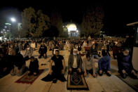 Muslim men pray next to the Dome of the Rock Mosque in the Al Aqsa Mosque compound in Jerusalem's old city, Sunday, May 31, 2020.The Al-Aqsa mosque in Jerusalem, the third holiest site in Islam, reopened early Sunday, following weeks of closure aimed at preventing the spread of the coronavirus. (AP Photo/Mahmoud Illean)