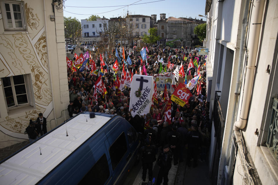 People demonstrate before French President Emmanuel Macron's visit, Thursday, April 20, 2023 in Ganges, southern France. The French leader tries to repair damage done to his presidency by forcing through unpopular pension reforms. Raising the retirement age from 62 to 64 has ignited a months-long firestorm of protest in France. (AP Photo/Daniel Cole)