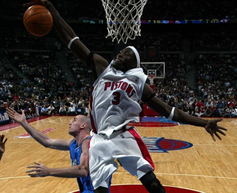 Pistons' Ben Wallace grabs a rebound past Orlando Magic's Pat Burke during the fourth quarter April 30, 2003 in Game 5 of the first round of the playoffs at the Palace of Auburn Hills.