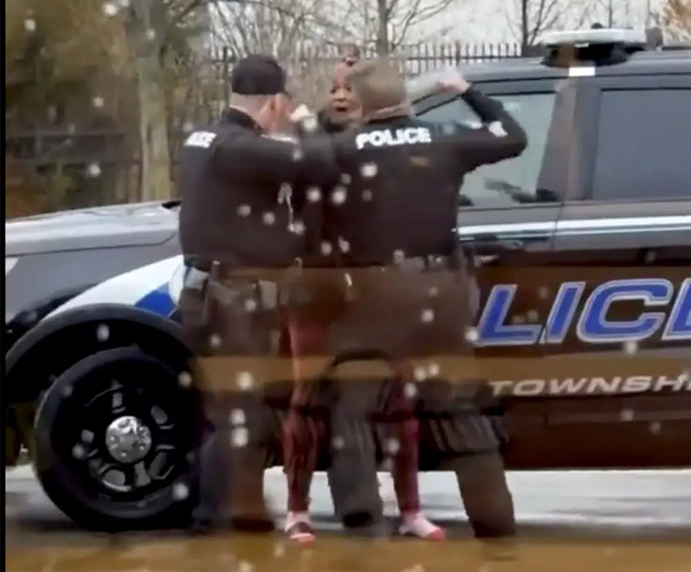 This screen grab made from video shows Butler Township officers Sgt. Tim Zellers, left, and Todd Stanley, right, restrain and arrest Laticka Hancock outside a McDonald’s restaurant in Butler Township, Ohio, on Monday, Jan. 16, 2023. (Mario Robinson/ LOCAL NEWS X /TMX via AP)