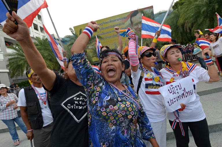 Anti-government protesters shout slogan outside the Constitutional Court in Bangkok on November 20, 2013