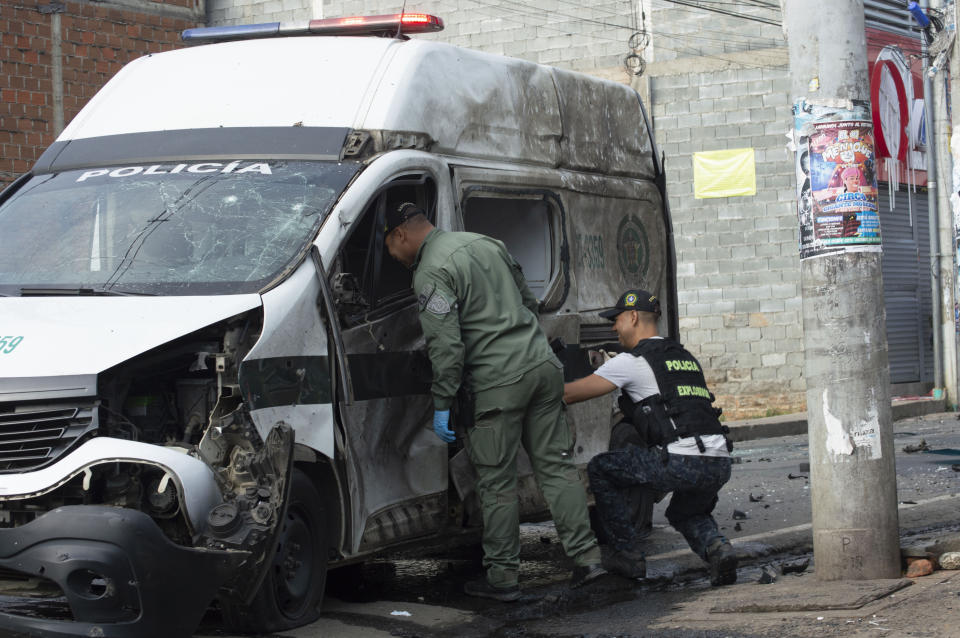 La policía inspecciona un vehículo policial dañado después de que explotara una motocicleta bomba en Jamundí, Colombia, el miércoles 12 de junio de 2024. (AP Foto/César Quiroz)