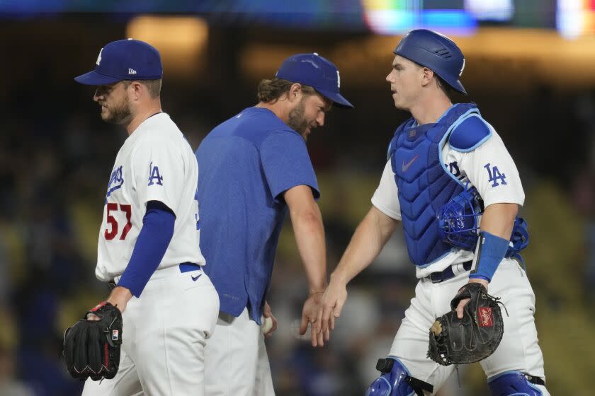 Los Angeles Dodgers' Clayton Kershaw, center, celebrates with relief pitcher Ryan Brasier (57) and catcher Will Smith.