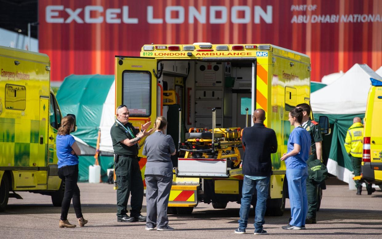 Paramedics and medical staff outside the NHS Nightingale Hospital at the ExCel centre in London. More patients who have recovered from Covid-19 and have cleared the infection are now still presenting with persistent symptoms - Dominic Lipinski/PA