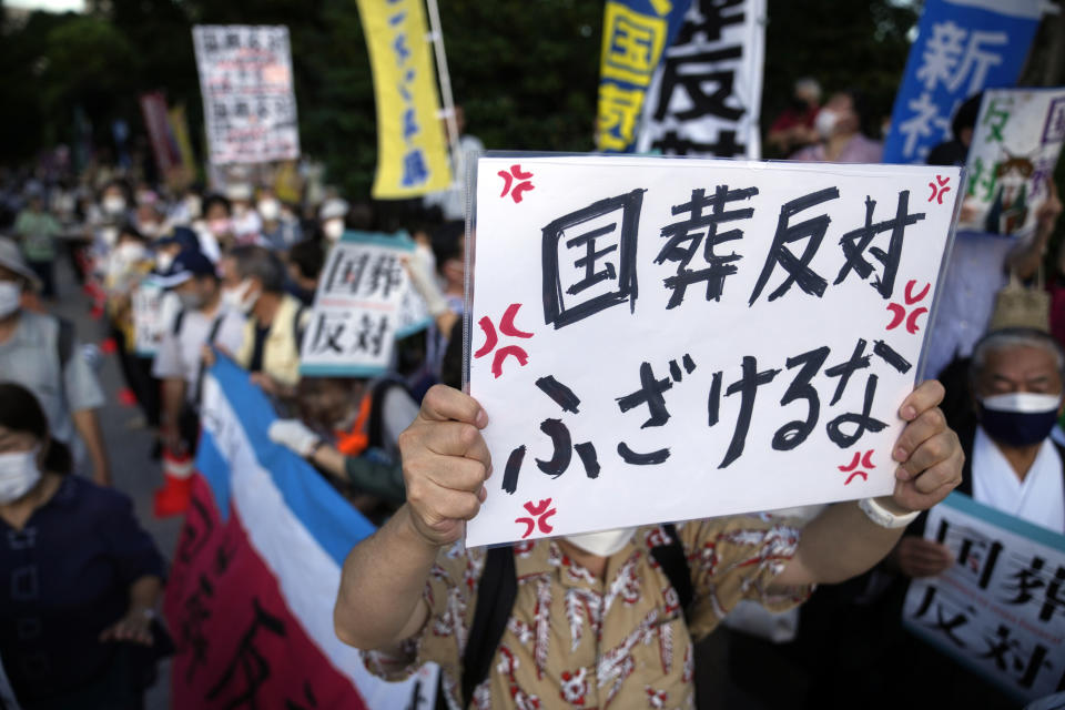 One of people holds a banner said in Japanese "No to State Funeral, Don't mess around " to protest outside Diet against the state paying for former Prime Minister Shinzo Abe's funeral, Wednesday, Aug. 31, 2022, in Tokyo. Japanese Prime Minister Fumio Kishida apologized for the loss of public trust because of the scandal and his lack of explanation for organizing a state funeral for Abe, one of most divisive leaders in Japan's postwar history. (AP Photo/Eugene Hoshiko)