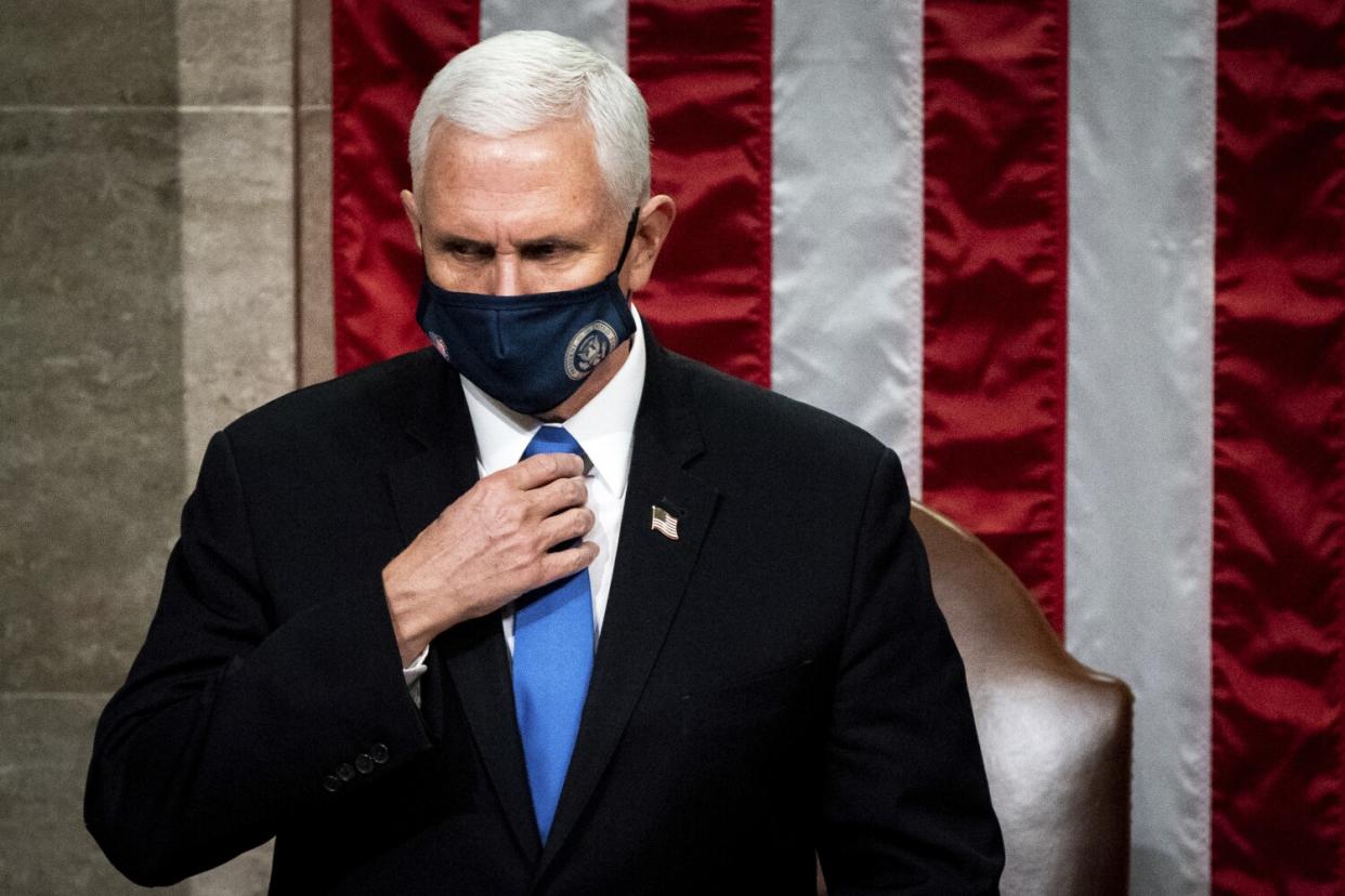 Then-Vice President Mike Pence standing before a large American flag