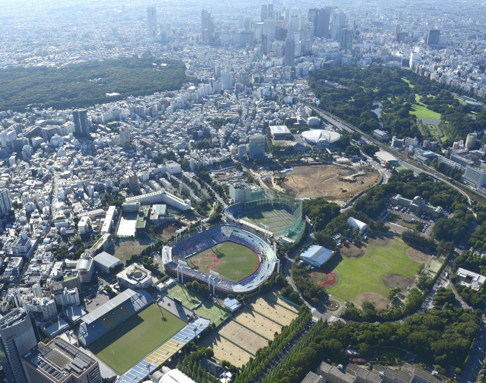 This photo shows the Meiji Jingu Stadium, center, in Tokyo on July 22, 2015. Above the Meiji baseball stadium is Jingu Daini, or Second, Stadium, the Chichibunomiya rugby stadium, bottom left, and a construction site for the National Stadium, center right, used for the 2020 Summer Olympics, which were postponed to 2021 due to the coronavirus pandemic. (Kyodo News via AP)