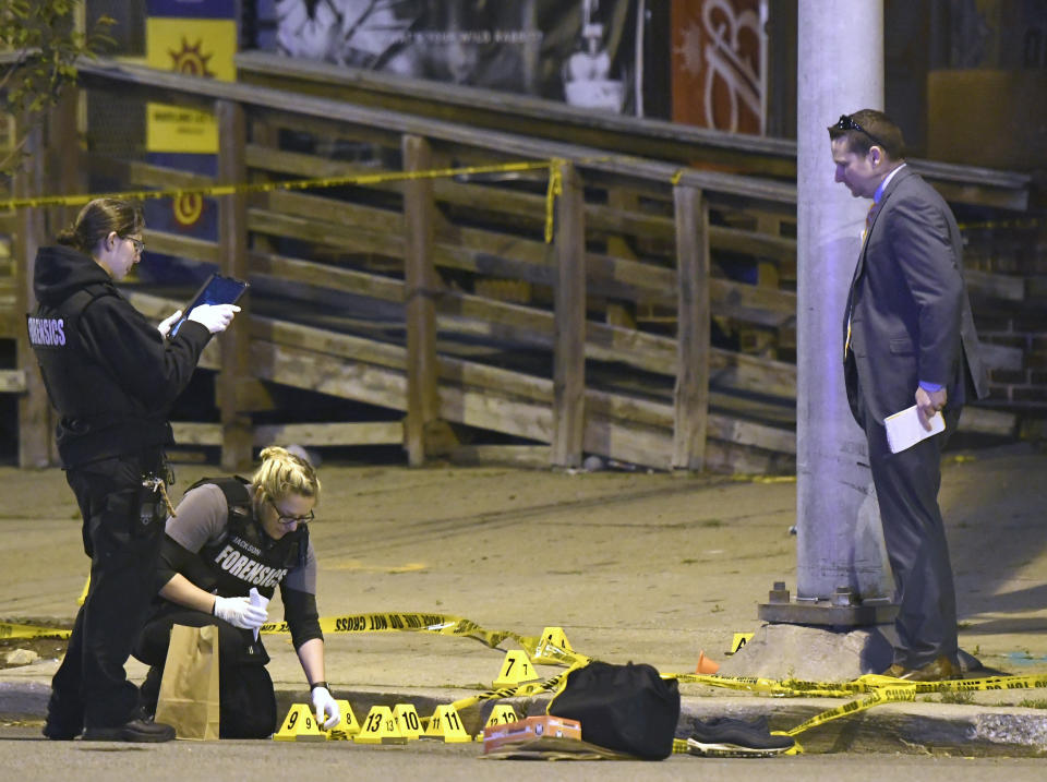 Police work near the scene where authorities say several people were shot, at least one fatally, Sunday, April 28, 2019, in Baltimore. (AP Photo/Steve Ruark)