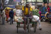 A man on his tricycle carries transports vegetables at a wholesale market in Guwahati, India, Wednesday, Feb. 1, 2023. Indian Prime Minister Narendra Modi's government ramped up capital spending by a substantial 33% to $122 billion in an annual budget presented to Parliament on Wednesday, seeking to spur economic growth and create jobs ahead of a general election next year. (AP Photo/Anupam Nath)