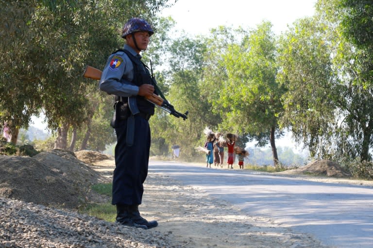 An armed Myanmar policeman stands guard on a road in northern Rakhine State from where tens of thousands of Rohingya have fled to Bangladesh to escape persecution