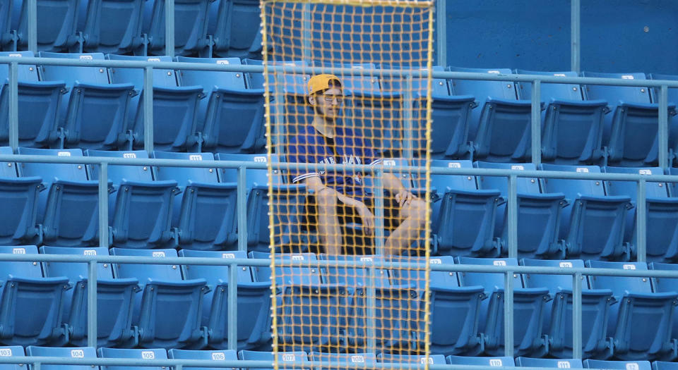 A fan of the Blue Jays watches from behind the loosely hanging mesh rectangles that pass as foul poles in Toronto. (Tom Szczerbowski/Getty Images)