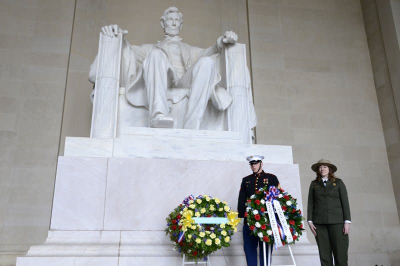 Acting Superintendent National Mall and Memorial Parks Karen Cururullo (R) stands at attention after presenting a wreath on February 12, 2018. On February 12, 1914, a dedication ceremony was held and the first stone of the Lincoln Memorial was laid. It took eight years to complete the monument. Photo by Mike Theiler/UPI