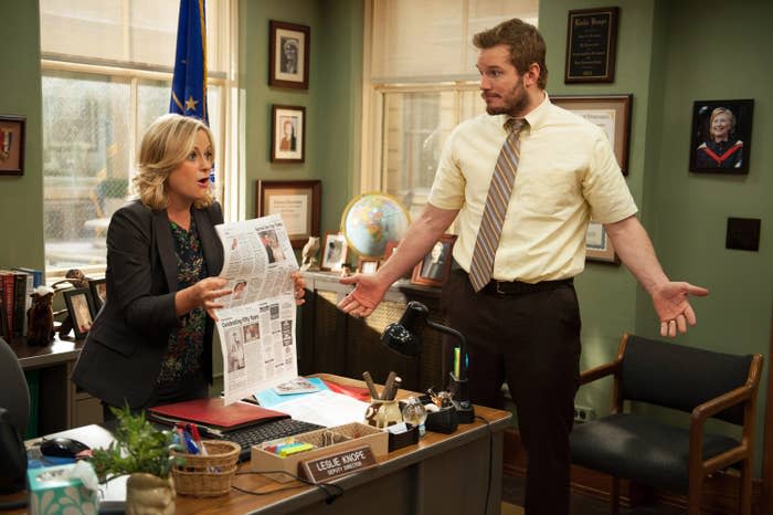 Andy standing next to Leslie's desk in "Parks and Rec"