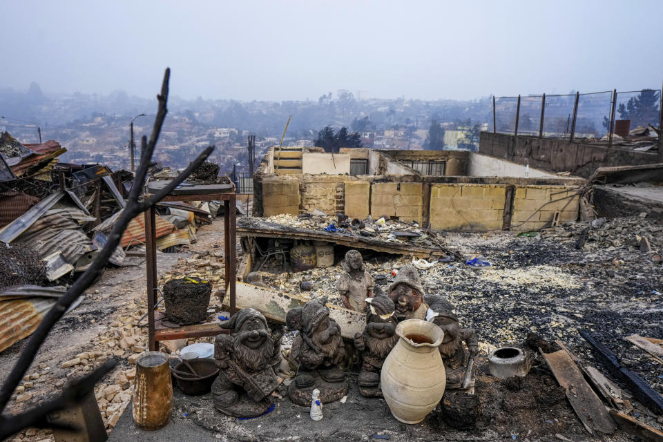 Garden gnomes are lined up in front of homes that were burnt when forest fires reached El Olivar neighborhood in Vina del Mar, Chile, Monday, Feb. 5, 2024. Areas around Vina del Mar were among the hardest-hit by fires that broke out in central Chile three day earlier, resulting in the deaths of more than a hundred people. (AP Photo/ Esteban Felix)