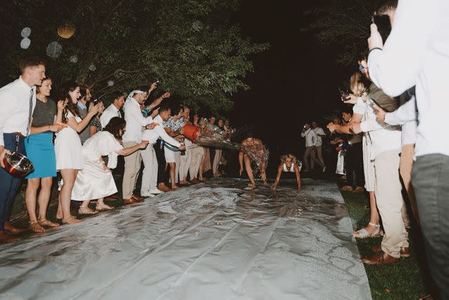 <p>Ciaran Mae Photo</p> Lindsey Harris and Rhett Harris leave their wedding in August 2019 on a slip and slide