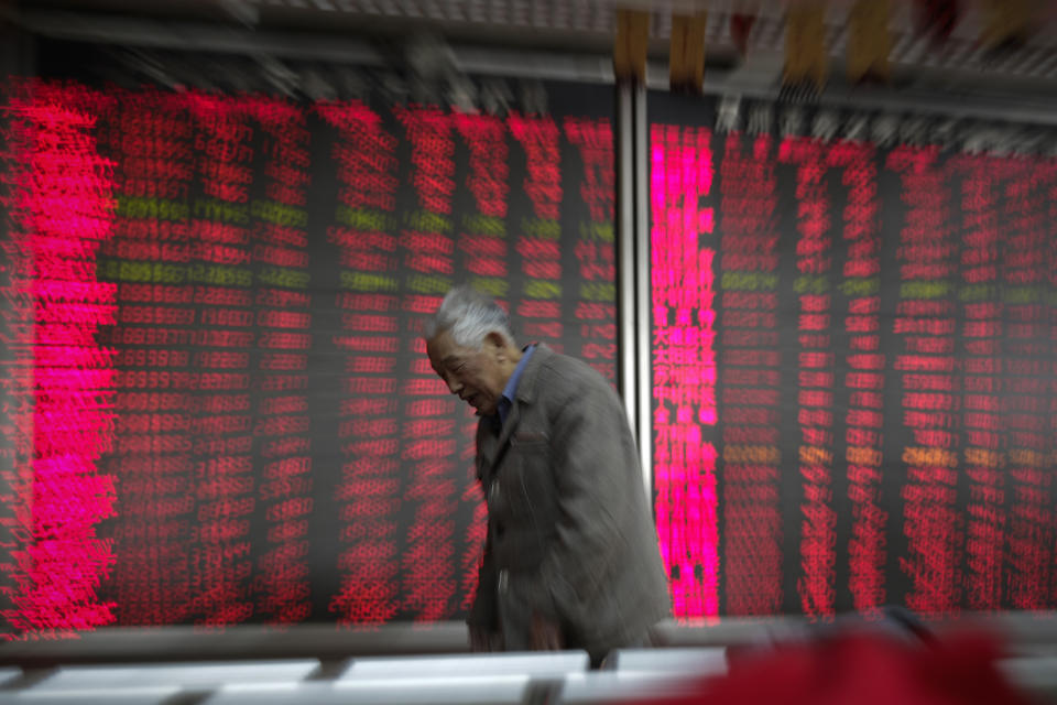 A man walks by an electronic board displaying stock prices at a brokerage house in Beijing, Wednesday, Jan. 9, 2019. Shares extended gains in Asia on hopes for progress in resolving the tariffs battle between the U.S. and China as talks appeared to have been extended in Beijing. (AP Photo/Andy Wong)