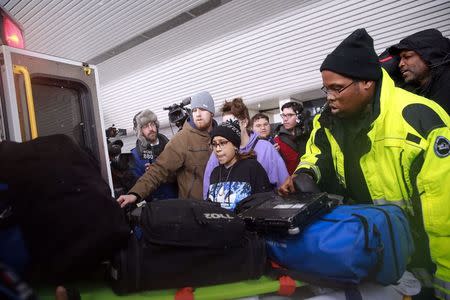 Emergency medical services workers direct passengers towards an ambulance at LaGuardia Airport's Terminal D in New York March 5, 2015. REUTERS/Shannon Stapleton