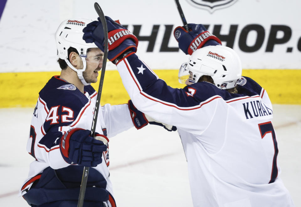 Columbus Blue Jackets forward Alexandre Texier (42) celebrates his goal against the Calgary Flames with forward Sean Kuraly (7) during the second period of an NHL hockey game Thursday, Jan. 25, 2024, in Calgary, Alberta. (Jeff McIntosh/The Canadian Press via AP)