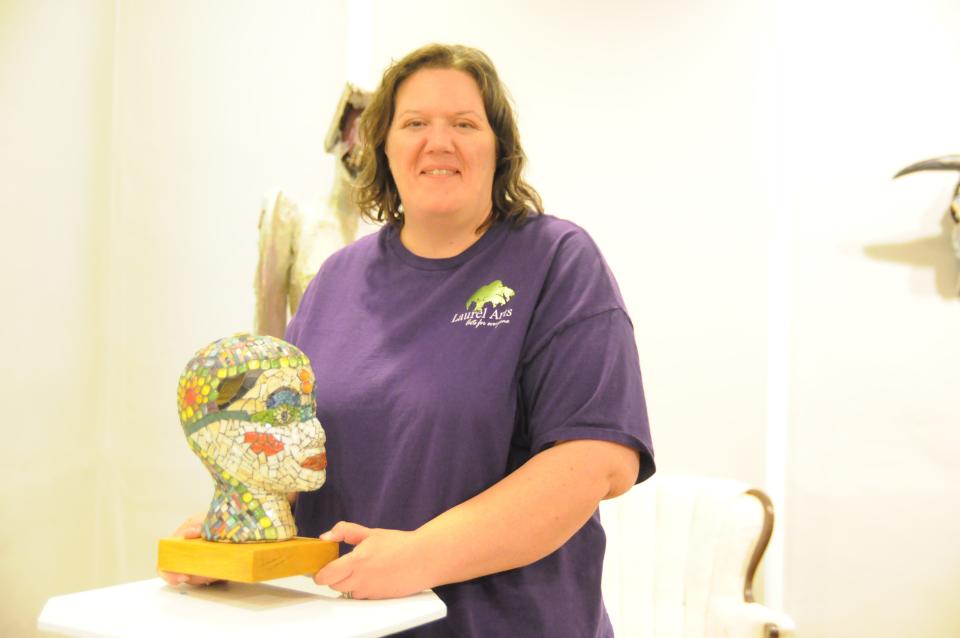 Artist and show coordinator Alison Leer with one of her pieces at "Off the Wall" exhibit at Laurel Arts. She worked with mosaic-glass on glass here. She did not name this piece, but she was contemplating something that may have to do with the great, late movie star, Joan Crawford.