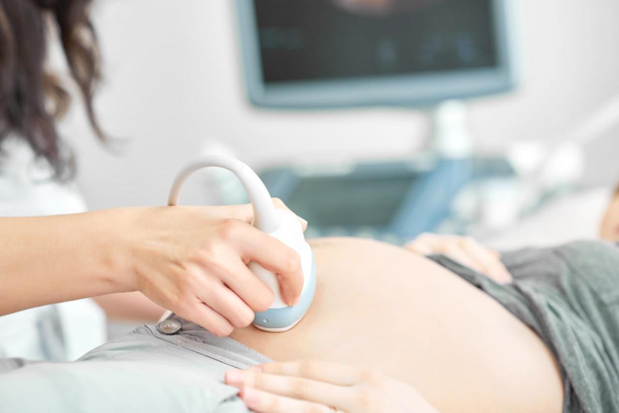 A medical professional does an ultrasound screening on a pregnant person. (Serhii Bobyk/Shutterstock - image credit)