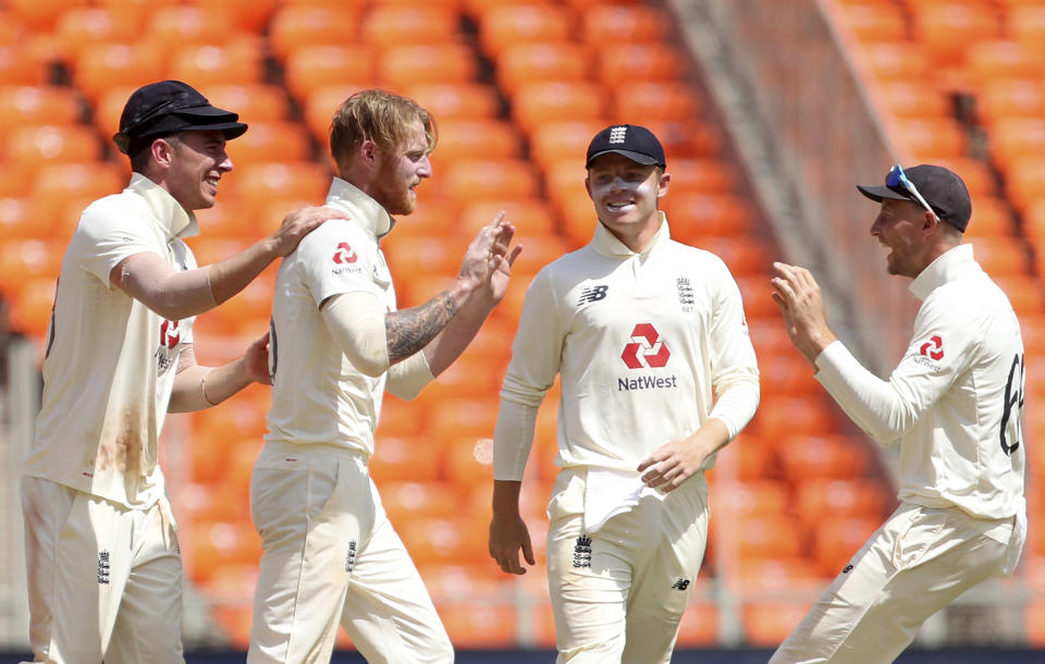 England's Ben Stokes, second left, and teammates celebrate the dismissal of India's Rohit Sharma during the second day of fourth cricket test match between India and England at Narendra Modi Stadium in Ahmedabad, India, Friday, March 5, 2021. (AP Photo/Aijaz Rahi)