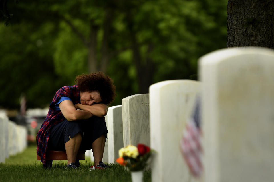 Andi Schorr grieves at the grave of her husband Sergeant First Class George Joseph Schorr. Schorr served two tours of duty in Vietnam and died in 1979 of cancer. Memorial Day ceremony, 84th Anniversary of Remembrance at Fort Logan National Cemetery. May 30, 2016 in Denver.