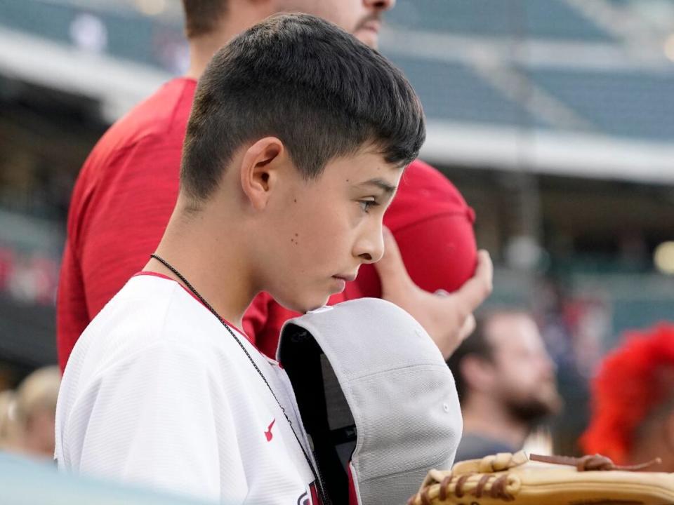 A young fan stands for a moment of silence for the victims of a school shooting in Texas prior to a baseball game between the Los Angeles Angels and the Texas Rangers on Tuesday in Anaheim, Calif.  (Associated Press - image credit)