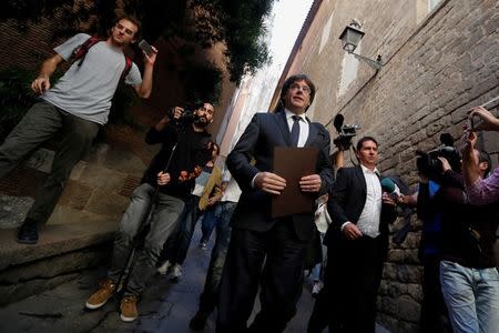 Catalan President Carles Puigdemont is surrounded by media as he leaves the regional government headquarters after delivering a statement in Barcelona, Spain, October 26, 2017. REUTERS/Yves Herman