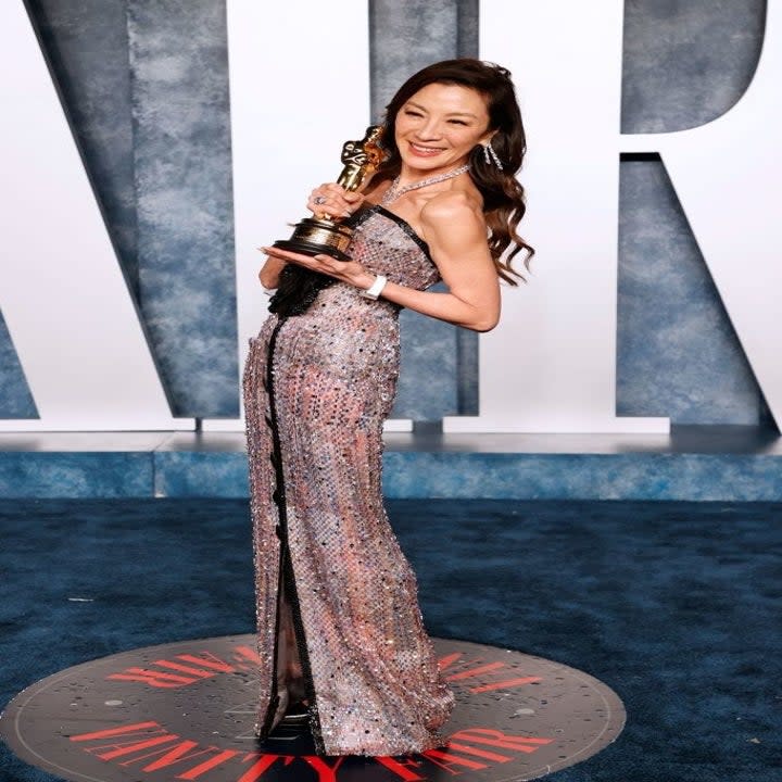 Michelle Yeoh holding her Oscar