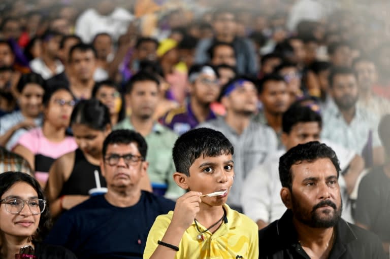 A young fan eats ice cream at a Kolkata Knight Riders match on Monday as a heatwave bakes the city (DIBYANGSHU SARKAR)
