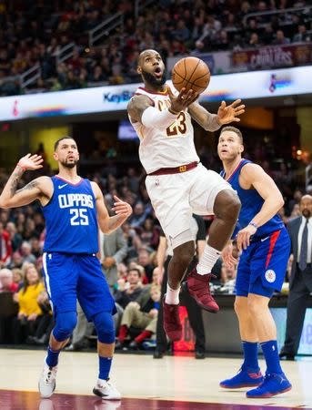 Nov 17, 2017; Cleveland, OH, USA; Cleveland Cavaliers forward LeBron James (23) takes the ball to the basket between Los Angeles Clippers guard Austin Rivers (25) and forward Blake Griffin (32) during the fourth quarter at Quicken Loans Arena. Mandatory Credit: Scott R. Galvin-USA TODAY Sports