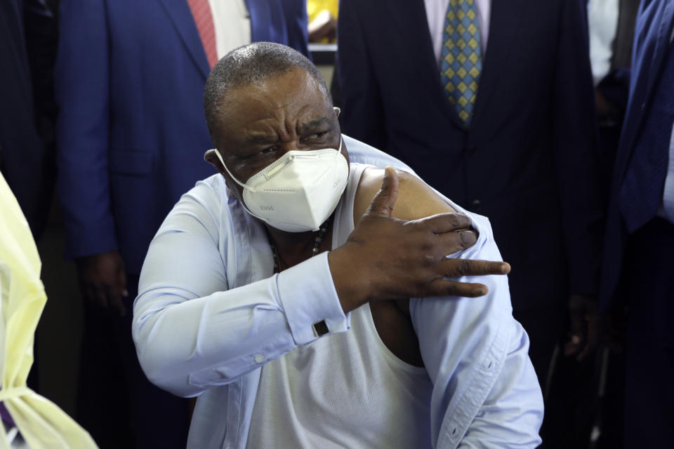 Zimbabwean Deputy President Constatino Chiwenga, reacts after getting a shot of China's Sinopharm vaccine, at local hospital in Harare, Thursday, Feb, 18, 2021. Chiwenga become the first person in the country to receive the jab, marking the first phase of the country's vaccination campaign.(AP Photo/Tsvangirayi Mukwazhi)