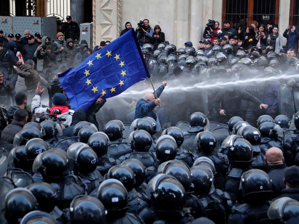 Riot police disperse opposition supporters during a protest rally in front of the parliament building in Tbilisi: EPA