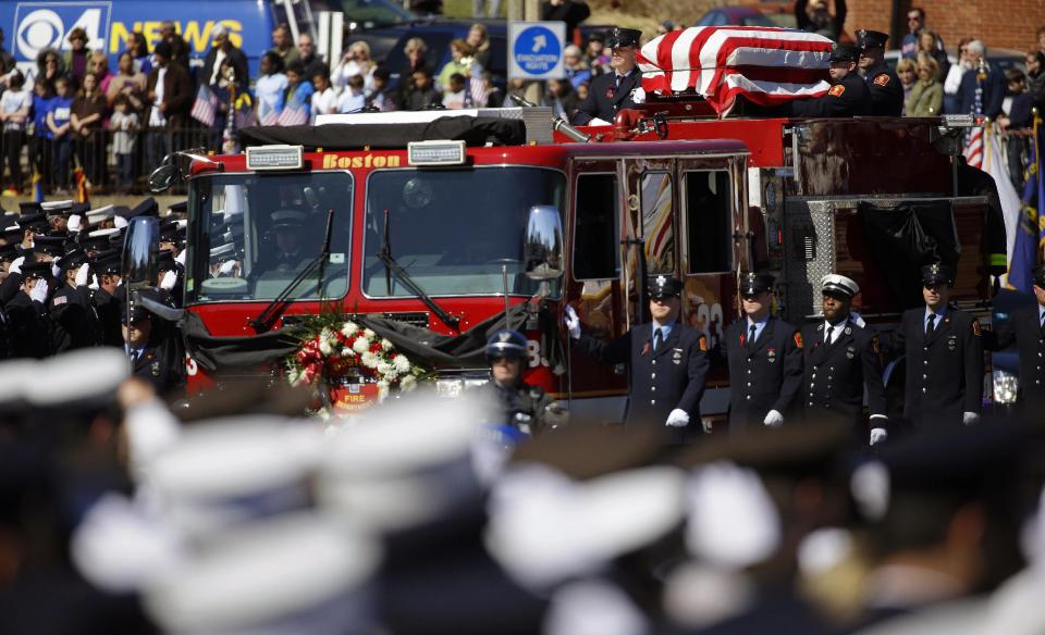 The funeral procession for Boston firefighter Michael R. Kennedy proceeds through saluting firefighters as it approaches Holy Name Church in Boston, Thursday, April 3, 2014. Kennedy and Boston Fire Lt. Edward J. Walsh were killed Wednesday, March 26, 2014 when they were trapped in the basement of a burning brownstone during a nine-alarm blaze.(AP Photo/Stephan Savoia)