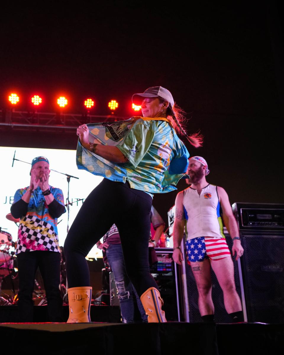 Jamie Spores of Ducktail Cycling Club shows off her team jersey during the best cycling jersey contest at the RAGBRAI route announcement party at Hy-Vee Hall in Des Moines on Jan. 28, 2023.