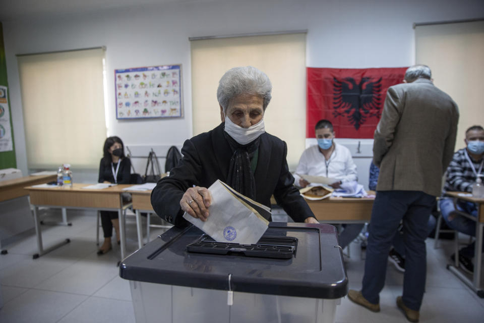 A woman casts her ballot during parliamentary elections in capital Tirana, Albania, Sunday, April 25, 2021. Albanians are voting in parliamentary elections amid the virus pandemic and a bitter political rivalry between the two largest political parties. (AP Photo/Visar Kryeziu)