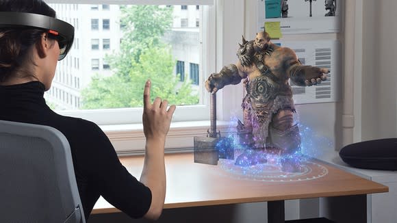 Woman using Microsoft's Hololens to play a game on a tabletop.