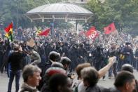 Masked youths with labour union flags are seen during clashes with French gendarmes and riot police during a demonstration in protest of the government's proposed labor law reforms in Paris, France, May 26, 2016. REUTERS/Charles Platiau