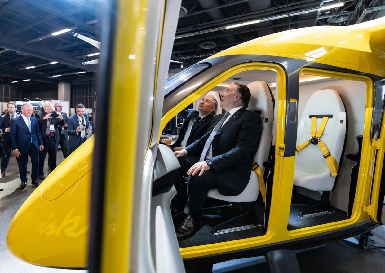 Quebec Premier François Legault, right, and Minister of Innovation, Science and Industry Francois-Philippe Champagne, sit in a Wisk, an autonomous air taxi on Tuesday. (Christinne Muschi/The Canadian Press - image credit)