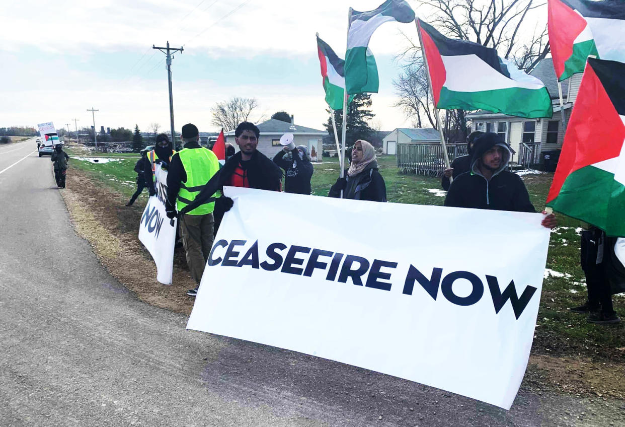 Protesters hold a sign that reads 