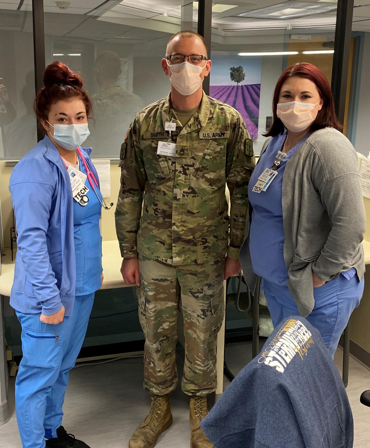 The Ohio National Guard has deployed five members to Southeastern Ohio Regional Medical Center to provide support staff assistance with non-medical duties. The mobilization of was ordered by Gov. Mike DeWine to assist providers during a record number of hospitalizations due to the COVID-19 pandemic. Ohio National Guard Sgt. First Class Adam Smith is pictured with patient technicians Shelby, left, and Becca at the Cambridge hospital.