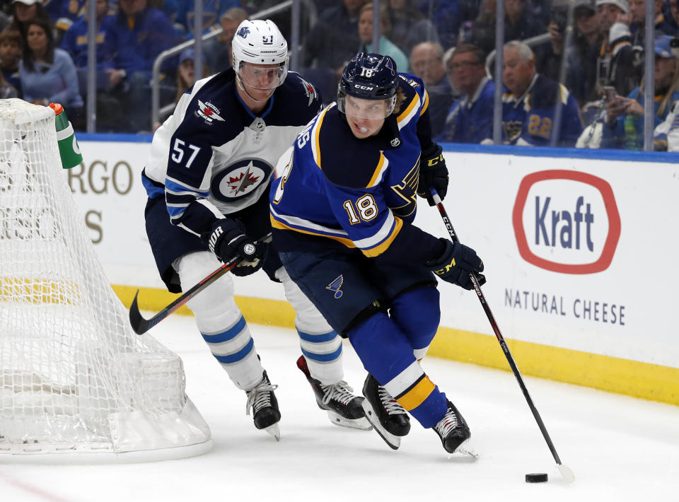 St. Louis Blues' Robert Thomas (18) handles the puck as Winnipeg Jets' Tyler Myers (57) defends during the second period in Game 3 of an NHL first-round hockey playoff series Sunday, April 14, 2019, in St. Louis. (AP Photo/Jeff Roberson)