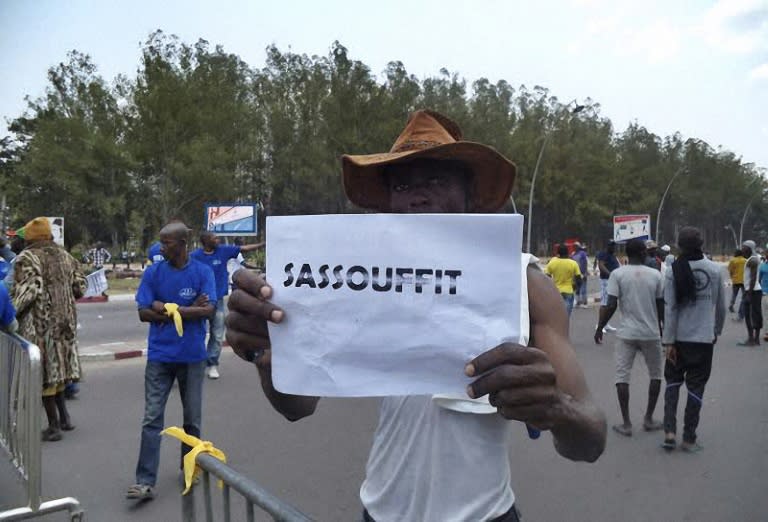 A man holds a placard with a play on words referring to the Congolese president and reading "Sassou enough" during an opposition demonstration in Brazzaville on September 27, 2015