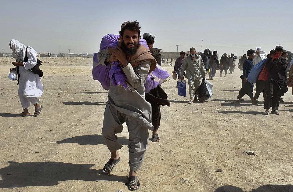 Stranded people gather and wait to open the border which was closed by authorities, in Chaman, Pakistan, Saturday, Aug. 7, 2021. Chaman border crossing is one of busiest border crossings between Pakistan and Afghanistan. Thousands of Afghans and Pakistanis cross daily and a steady stream of trucks passes through, taking goods to land-locked Afghanistan from the Arabian Sea port city of Karachi in Pakistan. (AP Photo/Tariq Achakzai)