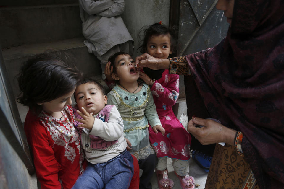 FILE - In this March 16, 2020 file photo, a health worker gives a polio vaccine to a child in Lahore, Pakistan. For millions of people who live in poor and troubled regions of the world, the novel coronavirus is only the latest epidemic. They already face a plethora of fatal and crippling infectious diseases: polio, Ebola, cholera, dengue, tuberculosis and malaria, to name a few. The diseases are made worse by chronic poverty that leads to malnutrition and violence that disrupts vaccination campaigns. (AP Photo/K.M. Chaudary, File)