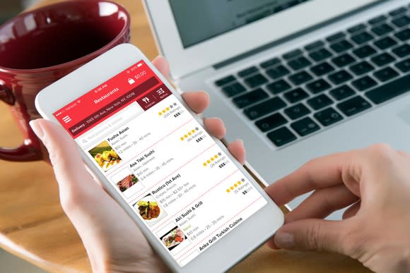 Person looking at restaurants on GrubHub's mobile app.