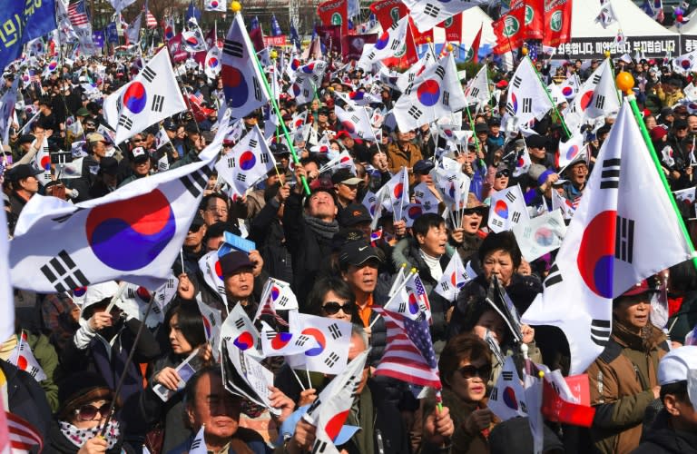 Supporters of South Korea's impeached-President Park Geun-Hye wave flags during a rally in Seoul