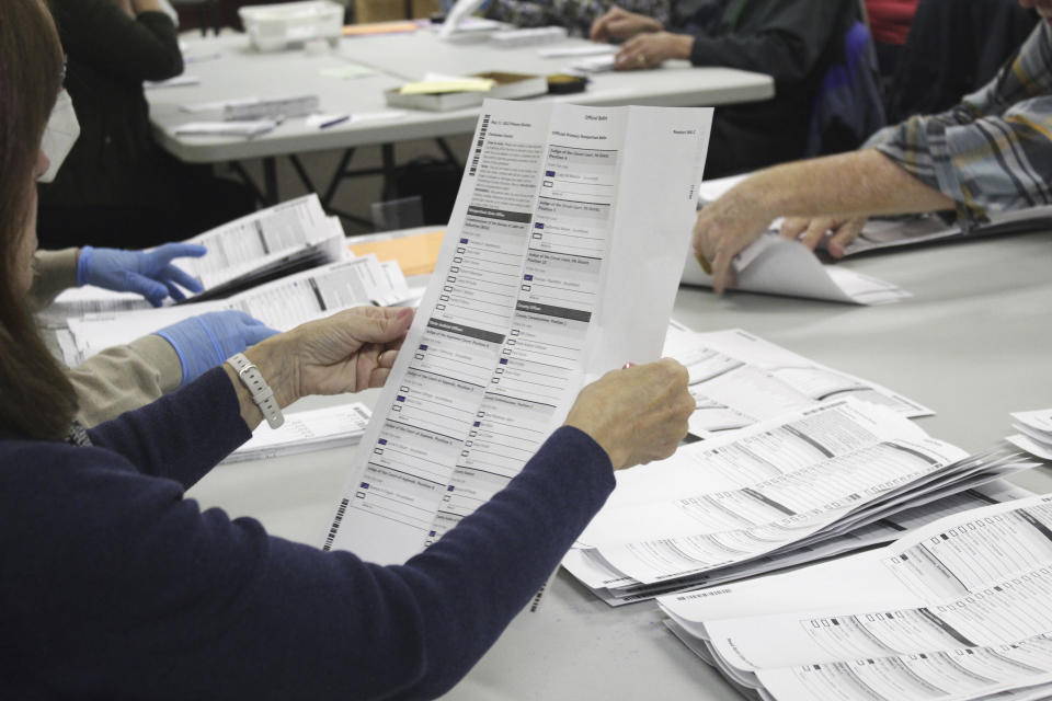 An election worker examines a ballot at the Clackamas County Elections office on Thursday, May 19, 2022, Oregon City, Ore. Ballots with blurry barcodes that can't be read by vote-counting machines will delay election results by weeks in a key U.S. House race in Oregon's primary. (AP Photo/Gillian Flaccus)